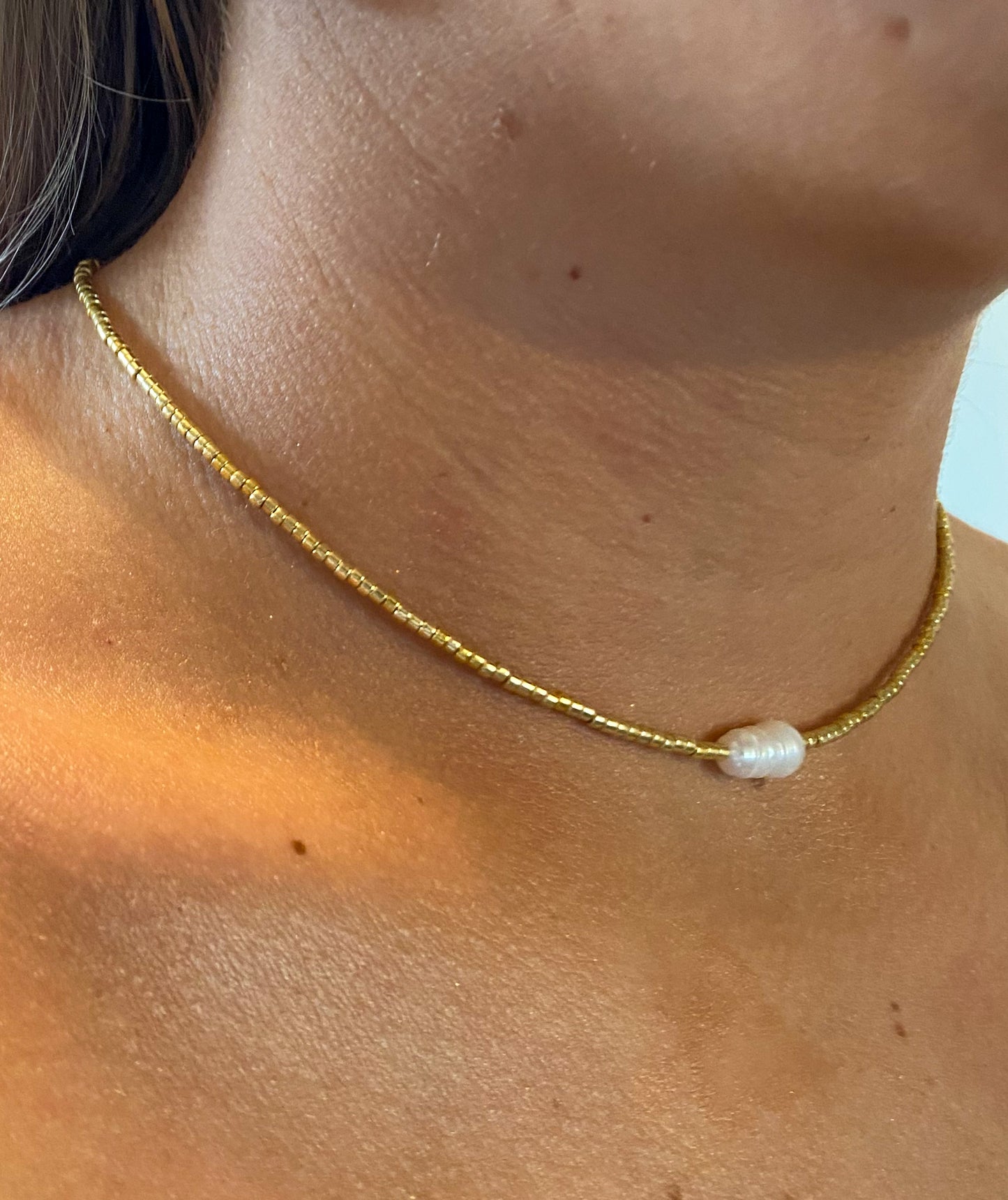 Gold beaded necklace with single pearl