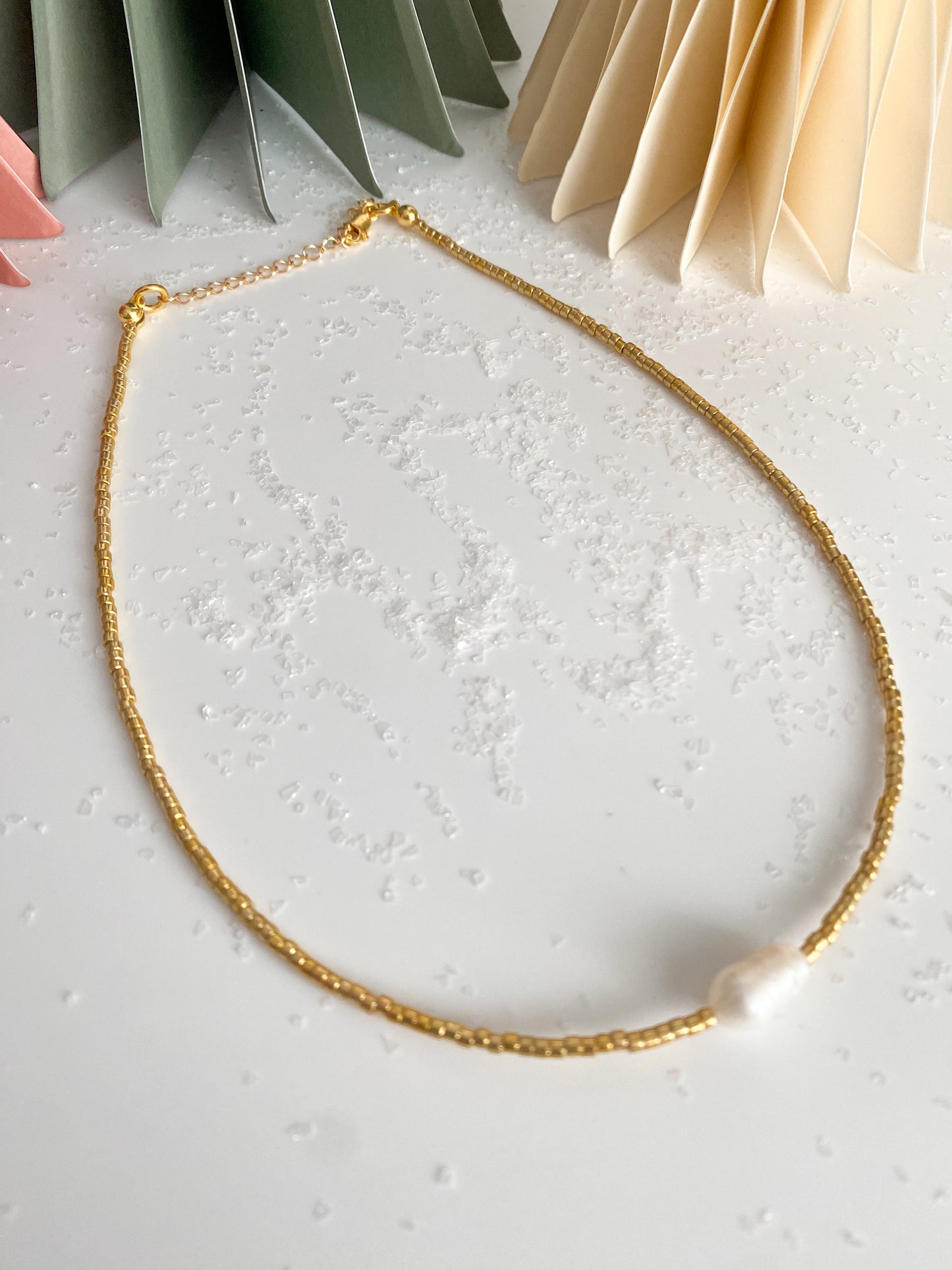 Gold beaded necklace with single pearl